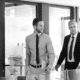 A group of business people standing in a glass walled office