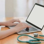 Can a Doctor Really Diagnose Over Zoom? Doctor sitting at a desk on telehealth call with stethoscope nearby
