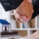 two people shaking hands in front of a desk