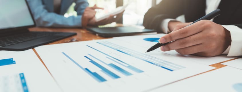 a person sitting at a desk with a pen in their hand