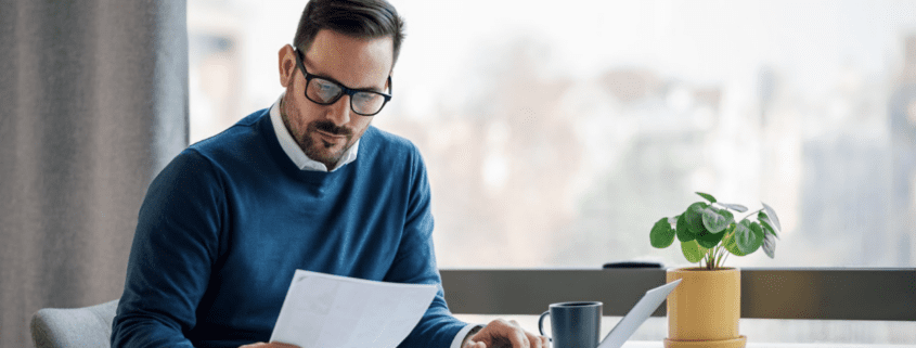 a man sitting at a table looking at a piece of paper