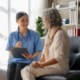 a nurse talking to a patient sitting on a chair